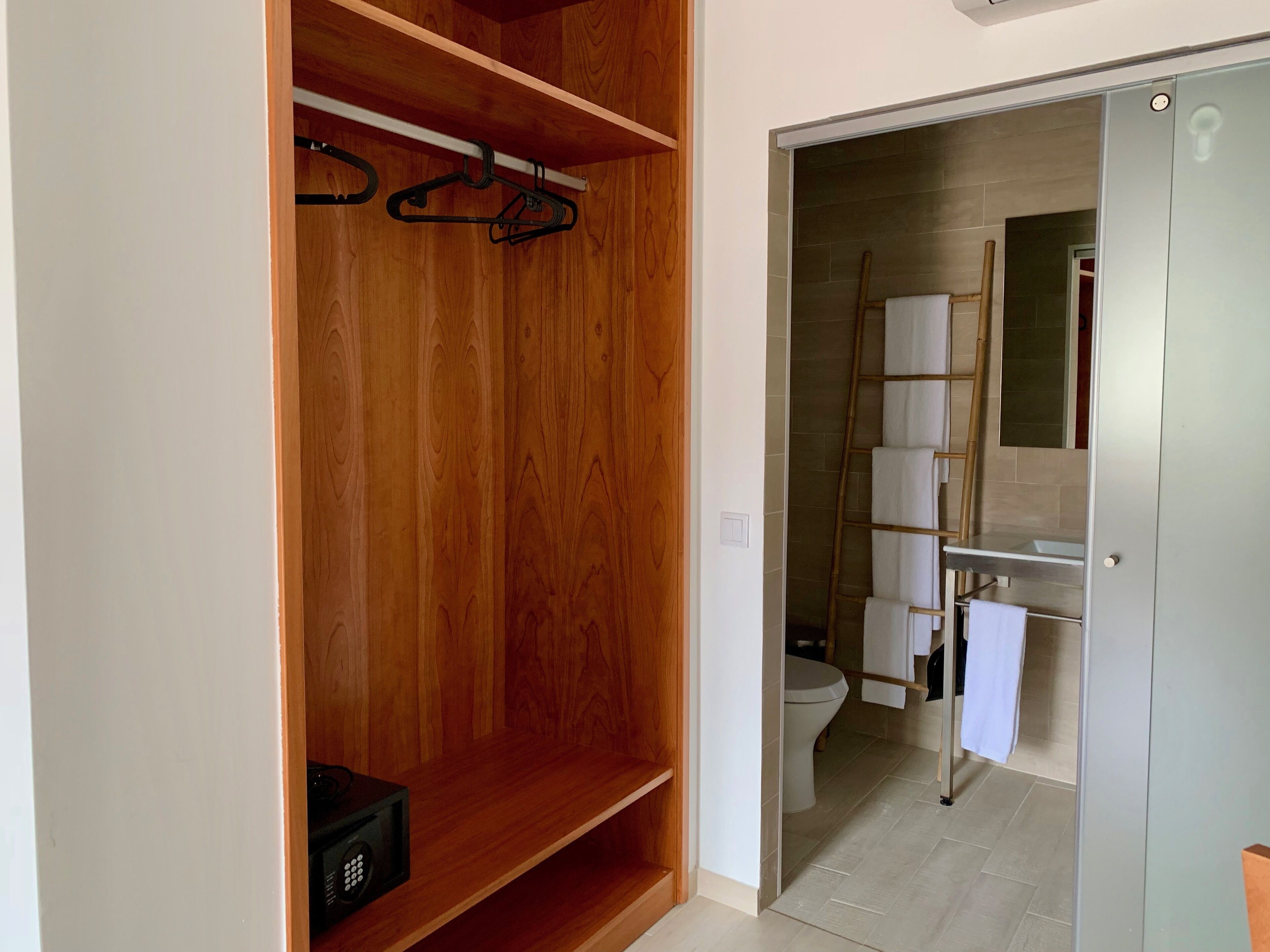 A modern bathroom with a wooden vanity, a toilet, and a shower area.