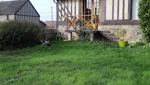Ein traditionelles Fachwerkhäuschen mit steinernen Fundamenten, einer Holztür und einer kleinen Veranda.