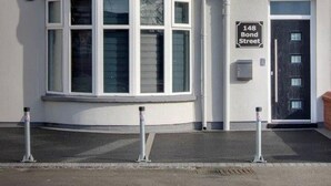 A two-story building with a bay window on the ground floor and a black door with a sign reading "148 Bond Street". - 2 Bedrooms Sleeps 6 Near Top Blackpool Attractions (Blackpool)