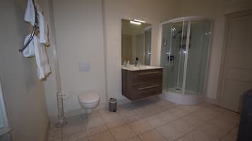 A bathroom with a toilet, sink, and shower.