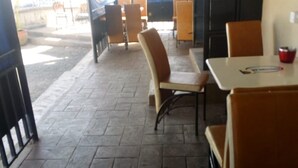 An indoor seating area with tiled flooring and tables and chairs. - Freetown Bar And Restaurant (Nairobi)