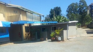 A small building with a blue awning, a sign that reads "GENTS", and a few potted plants. - Freetown Bar And Restaurant (Nairobi)