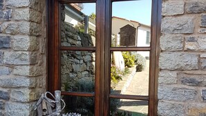 A stone building with a window featuring a wooden frame and a welcome sign. - DINOABBO FARMHOUSE APP. OLIVE TREES CITR:008033-AGR-0001 CIN IT008033B5JCTY5SHI (Lucinasco)
