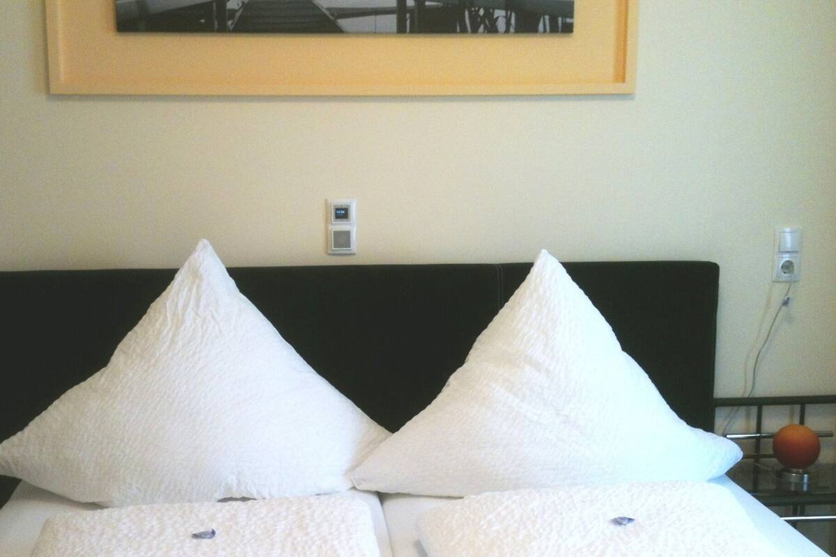 A bed with two white pillows and a black headboard.