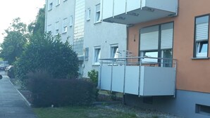 Un edificio con fachada plana, varias ventanas y un pequeño balcón.
