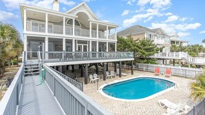 A two-story house with a balcony and a swimming pool. - All Aboard - Oceanfront in Garden City Beach (Garden City)