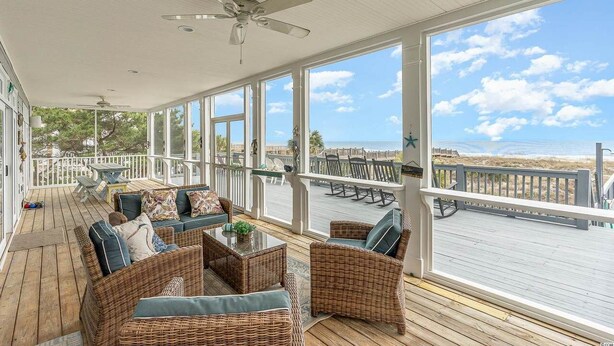 A covered outdoor area with wicker furniture, a ceiling fan, and a view of the beach. - All Aboard - Oceanfront in Garden City Beach (Garden City)