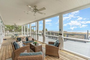 A covered outdoor area with wicker furniture, a ceiling fan, and a view of the beach. - All Aboard - Oceanfront in Garden City Beach (Garden City)