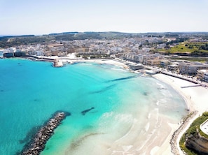 An aerial view of a coastal city with a clear blue sea, sandy beaches, and a mix of residential and commercial buildings. - Near The Beach And The Center Of Otranto - Apartment Eleonora 5 Places (Otranto)