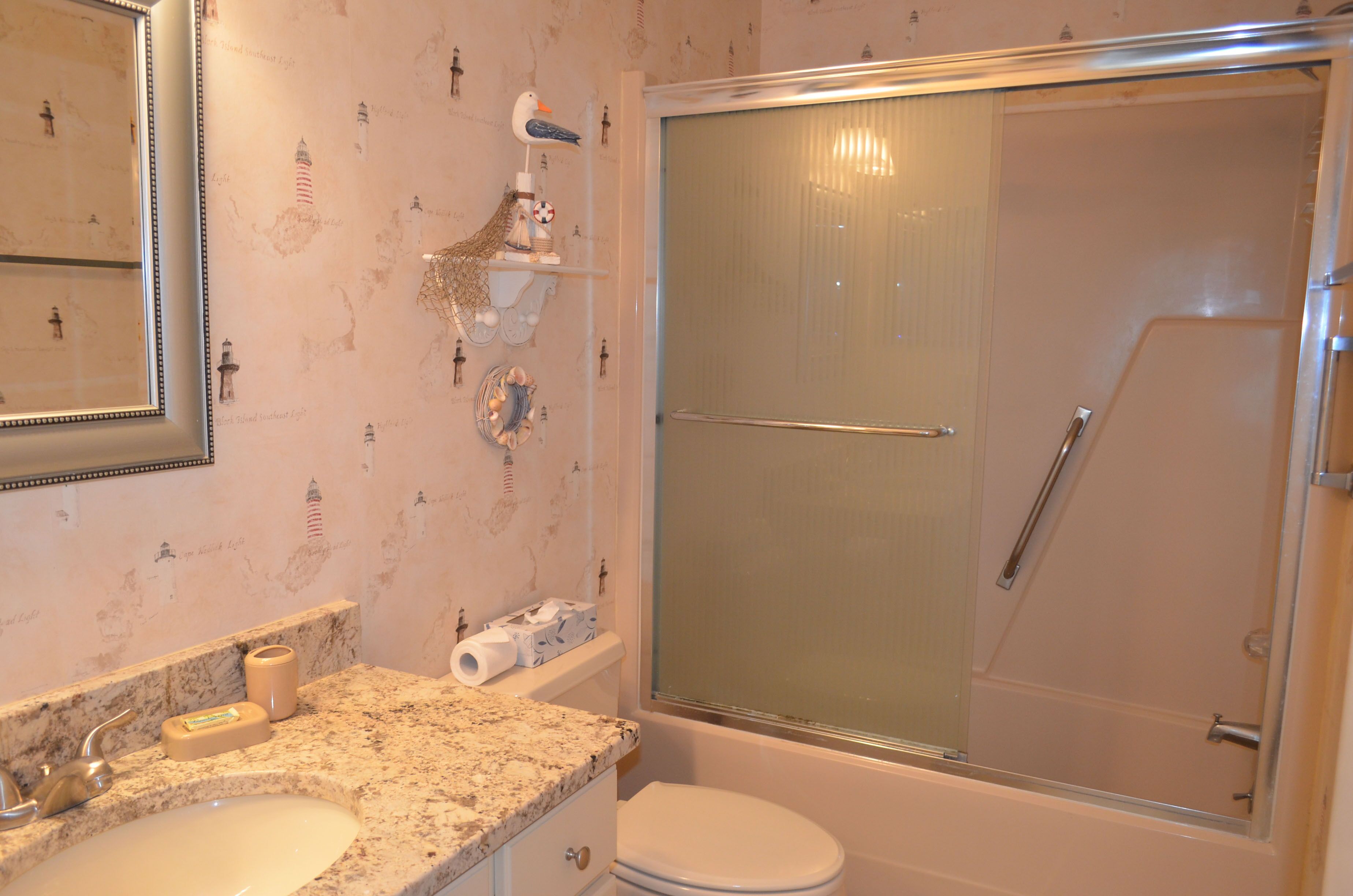 Une salle de bain avec un lavabo en marbre, des toilettes et une douche à parois de verre.
