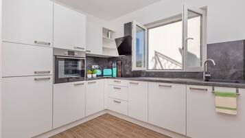 Apartamento, 2 quartos | Cozinha privada | Geladeira, cooktop, lava-louças, cafeteira/chaleira