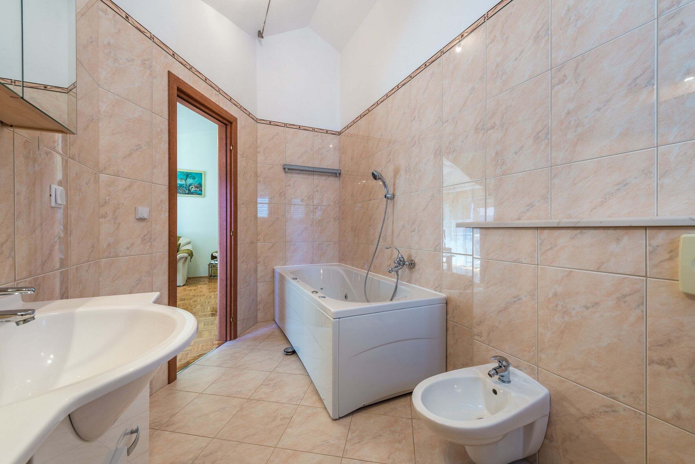 A modern bathroom with a bathtub, a bidet, and a large sink.