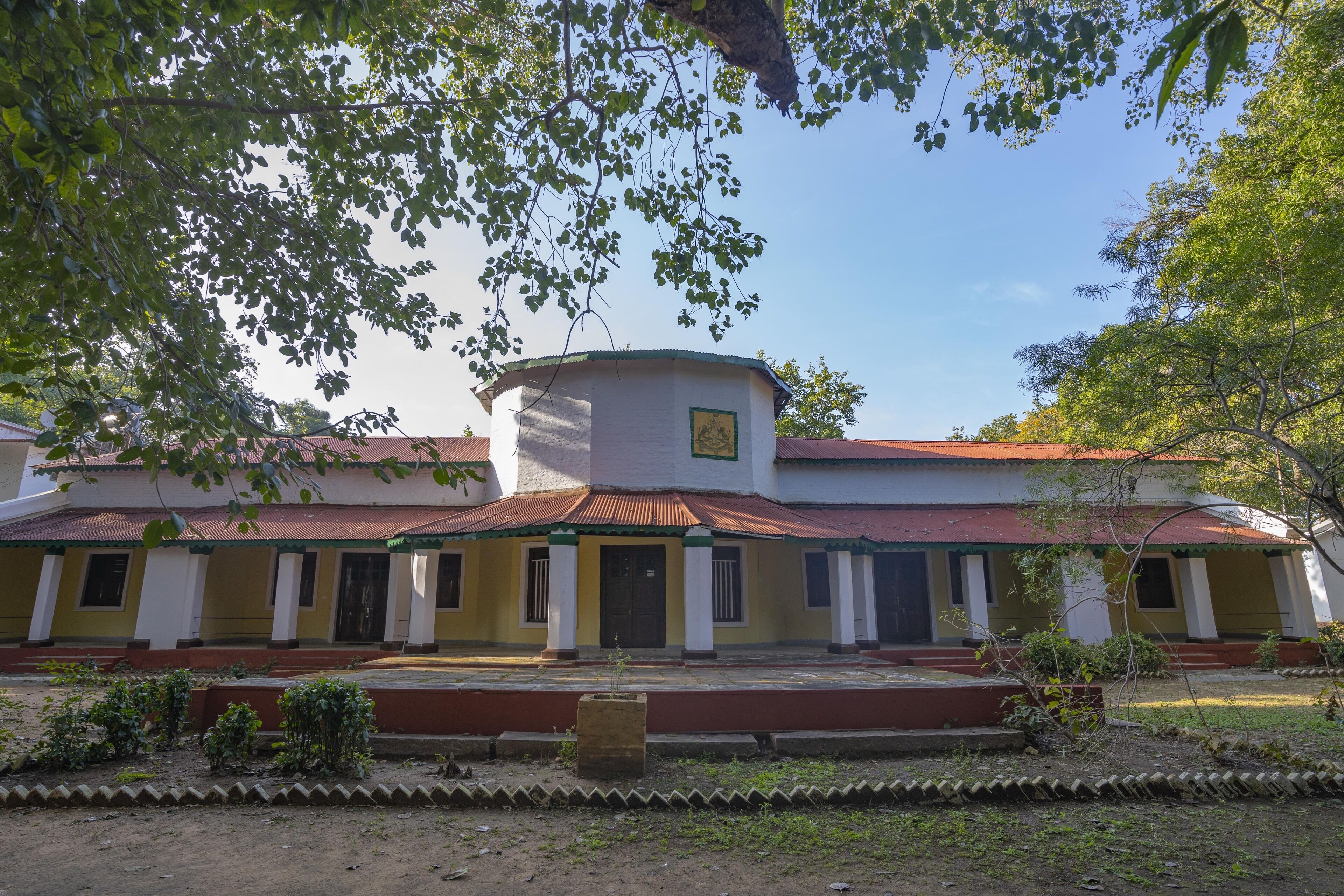 A building with a central circular structure, a covered entrance, and a symmetrical facade.