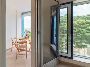 Ein Balkon mit Blick auf Bäume und einem Fliesenboden.