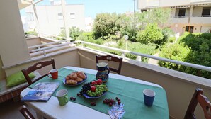 A balcony with a table set for breakfast, including croissants, fruit, and a pitcher. - In Good Location And With Balcony - Casa Vacanze Nicole In Salento (Otranto)