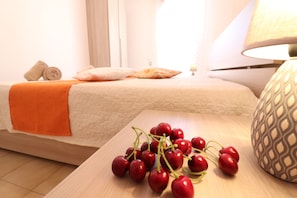 A hotel room with a bed, a bedside table with a lamp, and a wooden nightstand with a decorative item.