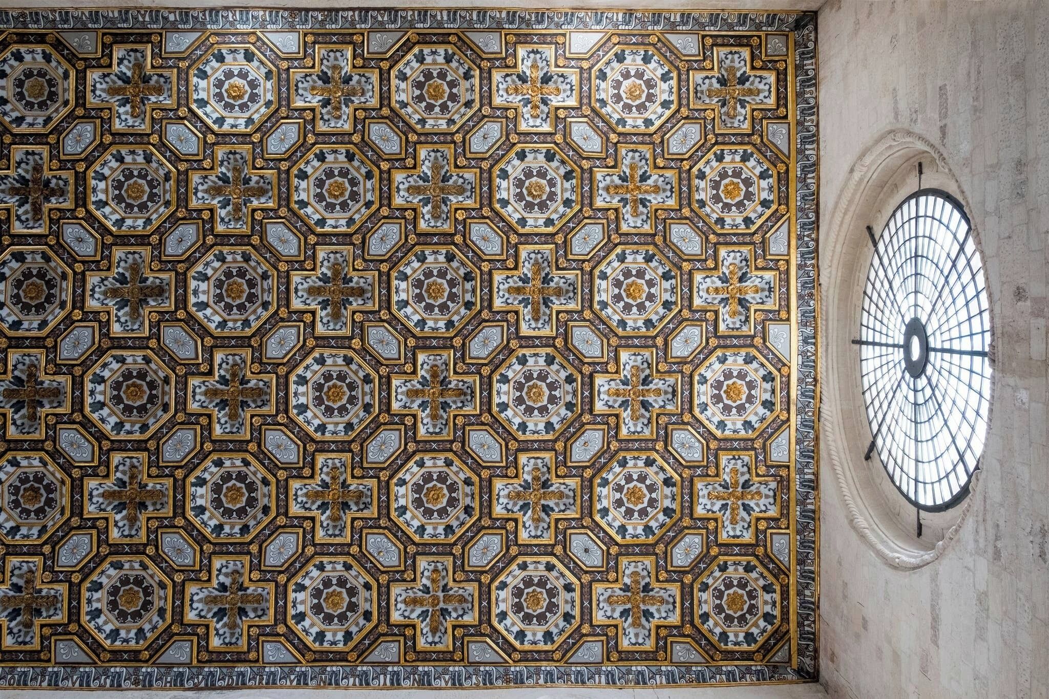 Ett detaljerat mosaiktak med geometriska mönster och kors.