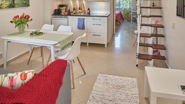 A modern apartment with a dining area, kitchen, and a loft bedroom. - Staylong Hotel (Taby)