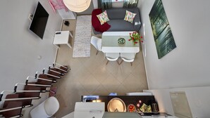 A modern living room with a sofa, a dining table, and a TV. - Staylong Hotel (Taby)