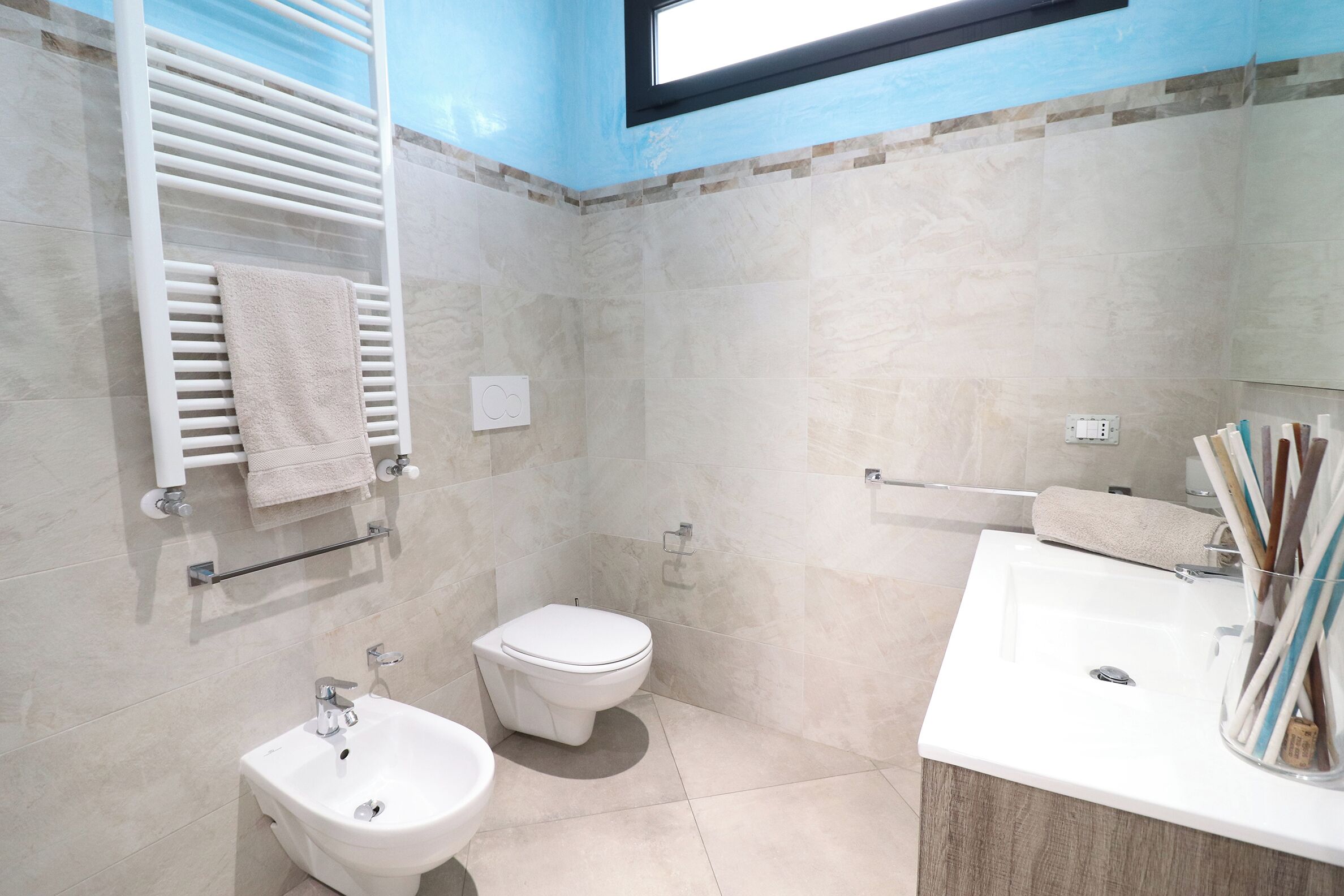 Un baño moderno con inodoro, bidé y lavamanos.
