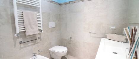 Un baño moderno con inodoro, bidé y lavamanos.
