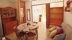 A dining area with a round table, chairs, and a cabinet. - Nice House Cecilia in Otranto (Otranto)