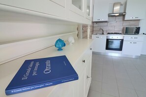 Una cocina moderna con armarios blancos, una estufa y un microondas.