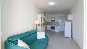 A modern kitchen with white cabinets, a stove, and a refrigerator. - Casa Lucrezia Unique Sea View and Relaxation Near the Historic Centre (Otranto)