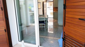 A sliding glass door leading to a dining area with a table and chairs. - Holiday Home Barbara (Otranto)