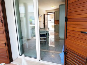 A sliding glass door leading to a dining area with a table and chairs.