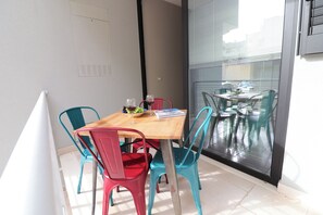 A dining area with a wooden table, four chairs, and a glass partition. - Modern Apartment "casa Giuditta Deluxe A Otranto" (Otranto)