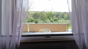 A balcony with a view of a forested area, a white chair, and a table. - Holiday's Home Claudia 6 People (Otranto)
