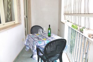 A balcony with a table set for two, a bottle of wine, and two chairs. - Holiday Apartment Karm Otranto 6 Places (Otranto)
