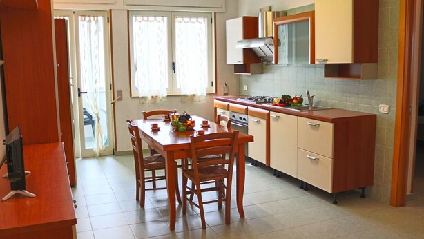 A compact kitchen with a dining table, chairs, and a stove. - Holiday Apartment Karm Otranto 6 Places (Otranto)