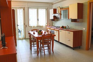 A compact kitchen with a dining table, chairs, and a stove. - Holiday Apartment Karm Otranto 6 Places (Otranto)