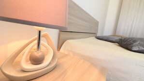 Una cama con cabecera de madera, una lámpara de noche y un cojín.