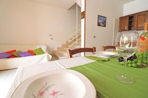 Une table à manger avec un verre à vin, des assiettes et une nappe verte.