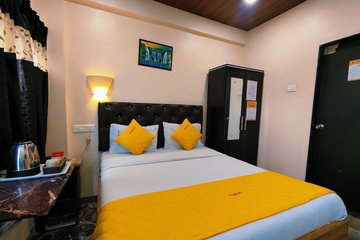 A hotel room with a bed, a nightstand, a wardrobe, and a painting on the wall.