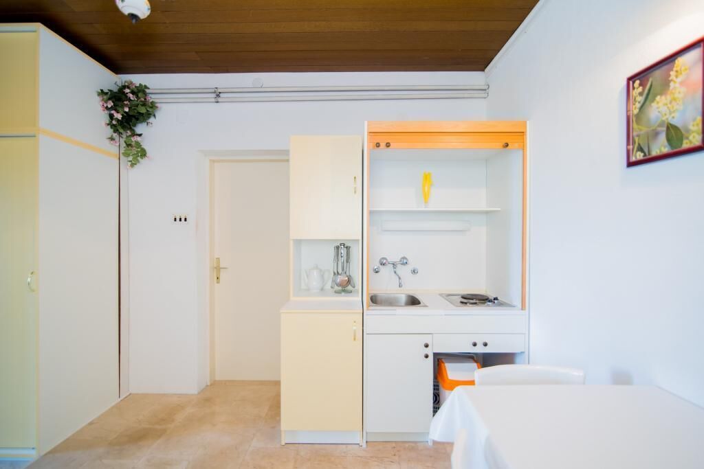 A compact kitchen with a sink, a small countertop, and a cabinet.