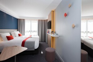 Een hotelkamer met twee bedden, een televisie, een klein tafeltje en een plank met toiletartikelen.