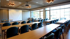A classroom with rows of desks and chairs, a projector, and a large window. - Thon Hotel Bronnoysund (Brønnøy)