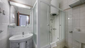 Un baño moderno con ducha de vidrio, lavamanos y retrete.