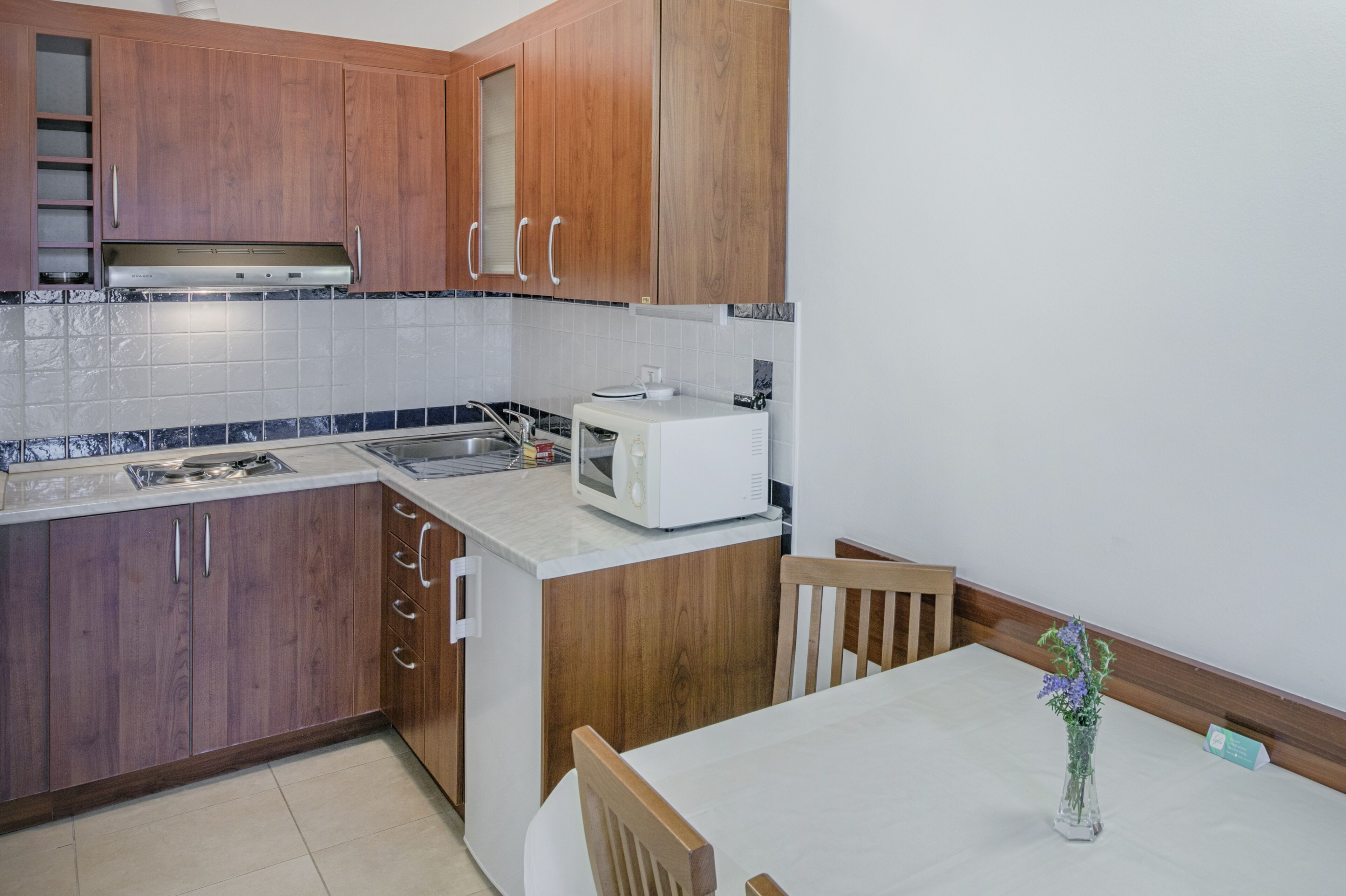 Una cocina con armarios de madera, un microondas y un fregadero.