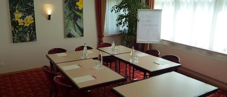 A conference room with tables, chairs, and a whiteboard.