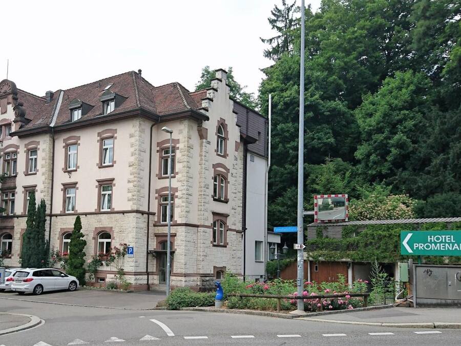 A historic building with a stone facade, multiple windows, and a traditional roof.