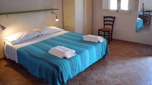 A bedroom with a bed, a wardrobe, a chair, and a window. - Il Bagolaro (Noto)