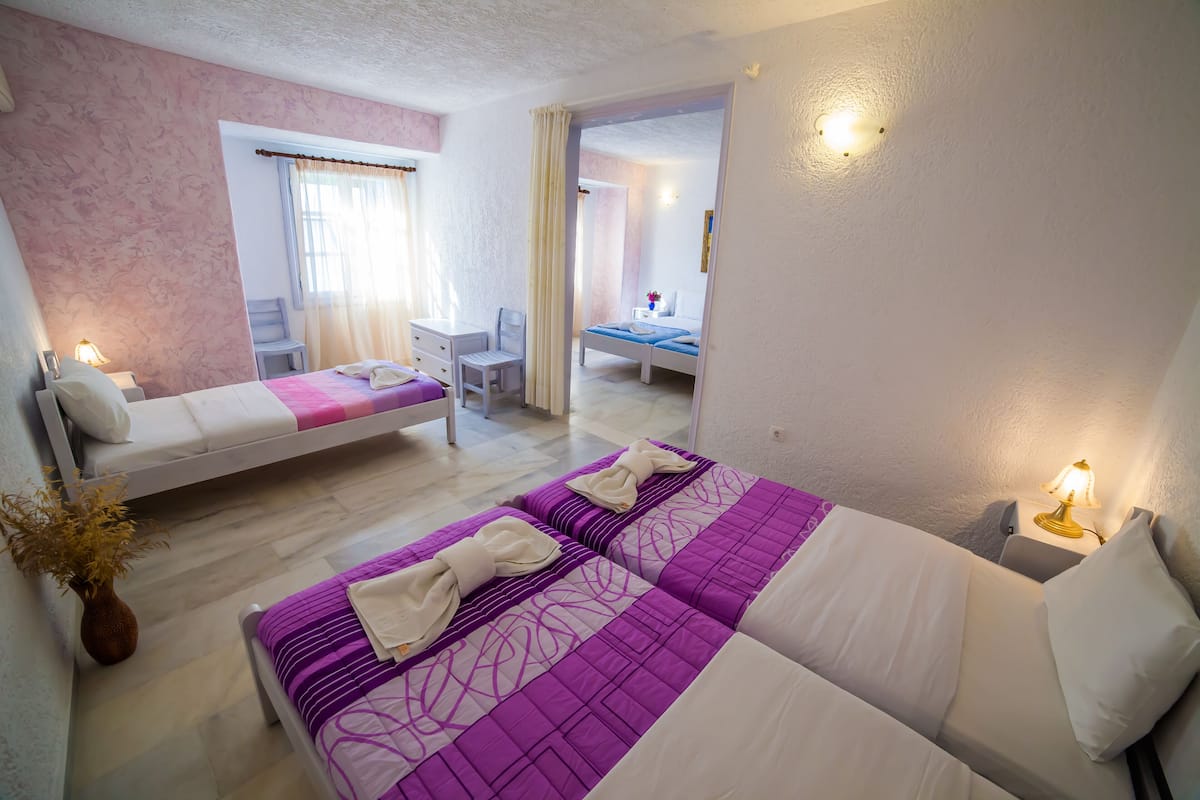 A hotel room with two beds, a desk, and a chair.