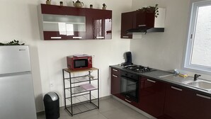 A compact kitchen with a refrigerator, microwave, stove, oven, and sink. - Functional holiday home 2 minutes from the beach (Ste anne)