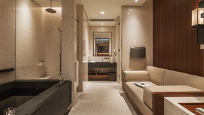 A modern bathroom with a bathtub, vanity, and a seating area. - Villa 32 (Taipei)