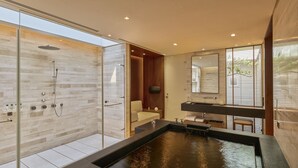 A modern bathroom with a glass-enclosed shower, a large sink with a water feature, and a wooden vanity. - Villa 32 (Taipei)